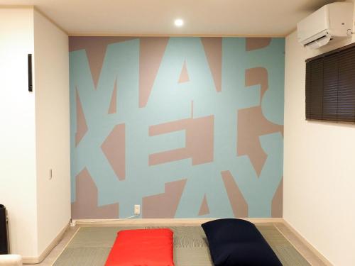 a bedroom with a bed with a colorful wall at マーケットステイ串本 MarketStay Kusimoto in Kushimoto