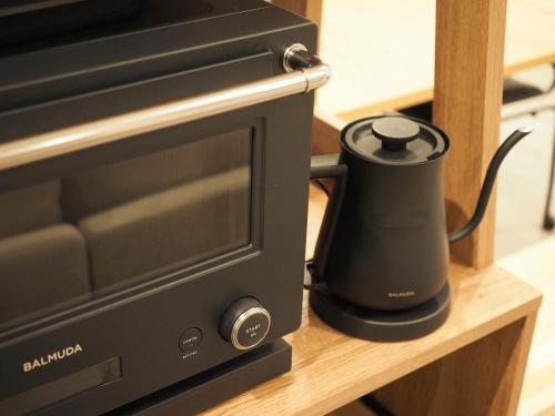 a black appliance sitting on a counter next to a microwave at マーケットステイ串本 MarketStay Kusimoto in Kushimoto