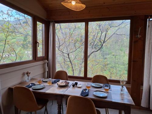 a table in a room with a large window at Auberge Arthéa in Laviolle