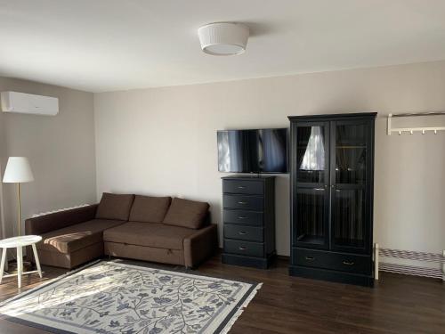 a living room with a couch and a entertainment center at Nordes in Ragaciems
