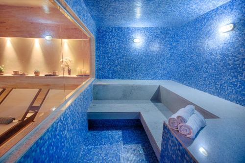 a blue bathroom with a bath tub with towels at Fusion Hplus Express + in Brasilia