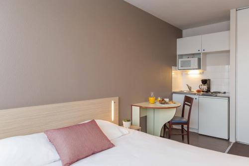 Cet appartement comprend une chambre avec un lit et une petite cuisine. dans l'établissement Appart'City Classic La Rochelle Centre, à La Rochelle