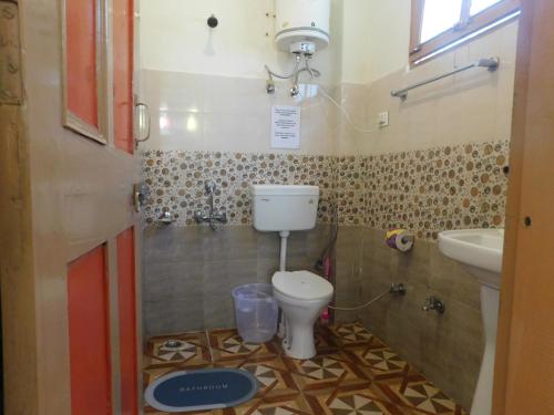 a bathroom with a toilet and a sink at The Sigiriya Old manali in Manāli