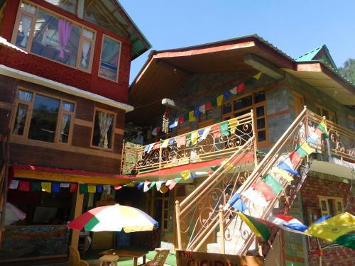 a building with flags and an umbrella in front of it at The Sigiriya Old manali in Manāli