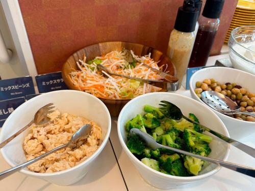 a table with three bowls of food on a table at Comfort Inn Niigata Kameda in Niigata