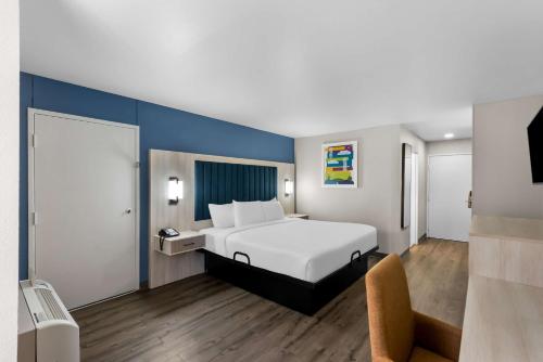 a bedroom with a white bed and a blue wall at Park Inn by Radisson in San Antonio