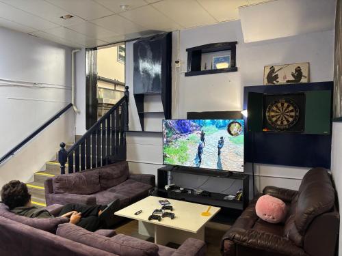 a man sitting in a living room watching tv at Albany Bayview Lodge in Albany