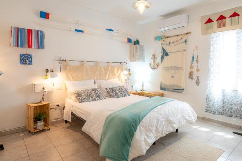 a bedroom with a bed with a white bedspread at Casa Vacanze - Domus De Mar in Stintino