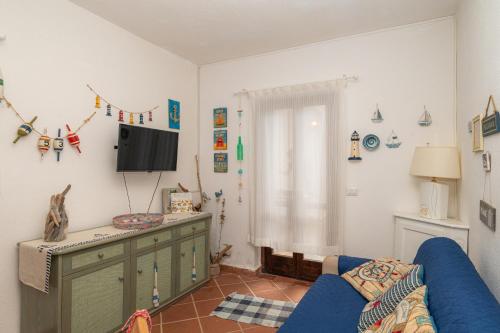 a living room with a blue couch and a tv at Casa Vacanze - Domus De Mar in Stintino