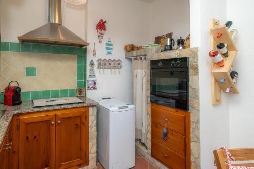 a kitchen with a stove and a washer and dryer at Casa Vacanze - Domus De Mar in Stintino