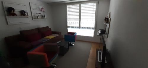 a living room with a couch and a window at Zimmer möbliert in Uznach in Uznach