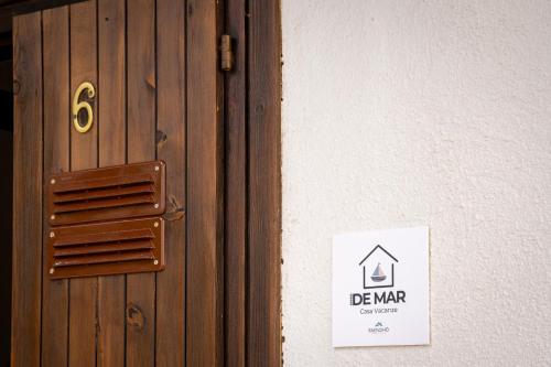 a door with a sign on the side of a building at Casa Vacanze - Domus De Mar in Stintino