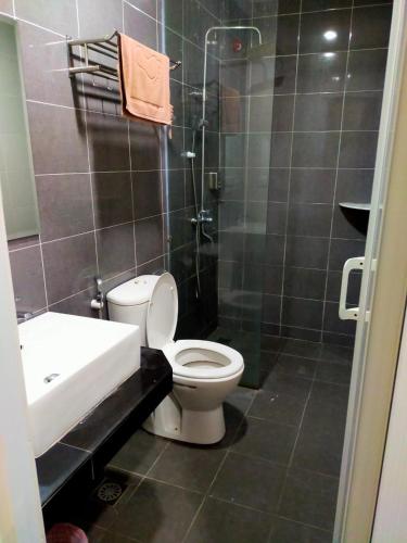 a bathroom with a toilet and a shower and a sink at Langkawi Uptown Hotel in Kuah