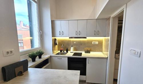 a kitchen with white cabinets and a sink at Studio Gea in Semedela