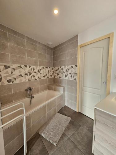 a bathroom with a tub and a sink at Chambre pleine de charme face à la muraille romaine et face à la cathédrale in Le Mans