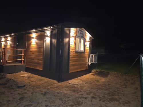 a wooden cabin at night with lights on it at Domek 2 Wdechy in Wdzydze Kiszewskie