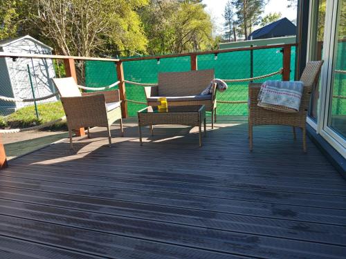 a porch with three chairs and a couch on it at Domek 2 Wdechy in Wdzydze Kiszewskie