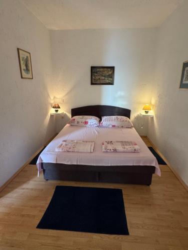 a bedroom with a bed with two lamps and a rug at Apartment GOLDENS with a sea view in Senj