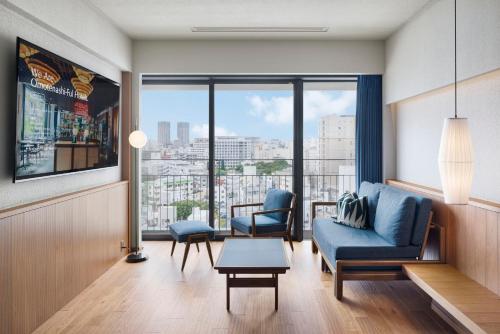a living room with a couch and chairs and a large window at Southwest Grand Hotel in Naha