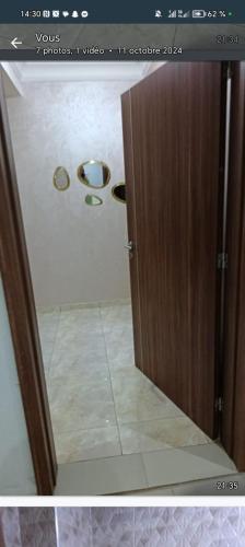 a bathroom with a door and a tile floor at Appartement bouskoura 2 chambres near aeroport in Bouskoura