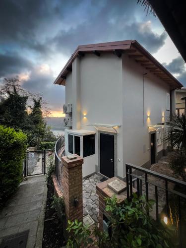 a white house with a sunset in the background at Klimt & Van Gogh Vista Lago by Abitare Il Tempo in Nemi