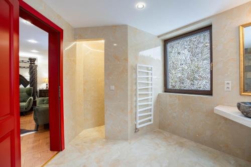 a bathroom with a red door and a window at Zámoček Mraznica in Prievidza