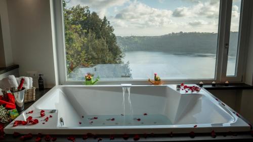 a bath tub in a kitchen with a large window at Klimt & Van Gogh Vista Lago by Abitare Il Tempo in Nemi