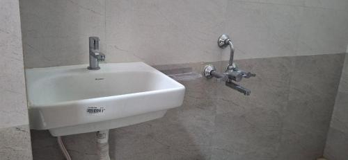 a white sink on a wall in a bathroom at SSK Rooms in Gūduvāncheri