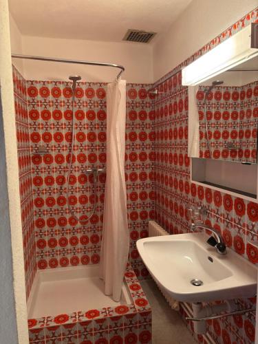 a bathroom with a white sink and a shower at Familiehotel La Randulina in Ramosch