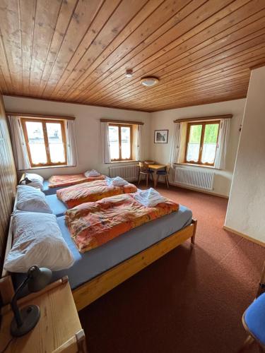 a bedroom with four beds in a room with wooden ceilings at Familiehotel La Randulina in Ramosch