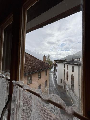 a window with a view of a street and buildings at Familiehotel La Randulina in Ramosch