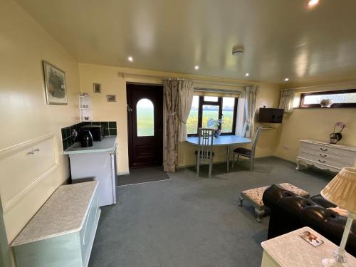 a room with a kitchen and a living room with a table at Pheasant Suites in Colchester