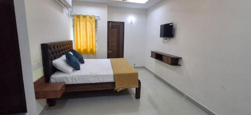 a bedroom with a bed with a yellow curtain at SSK Rooms in Gūduvāncheri