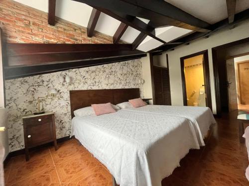 a bedroom with a bed and a brick wall at Posada Rural La Peña Casares in La Revilla