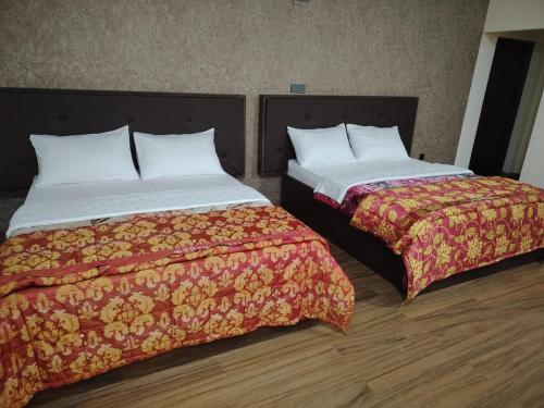 two beds sitting next to each other in a room at Hotel Winchester in Nuwara Eliya