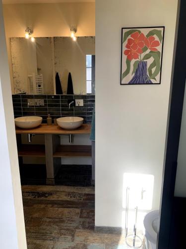 une salle de bain avec deux lavabos et un grand miroir dans l'établissement La Parenthèse Bourguignonne, à Savigny-lès-Beaune