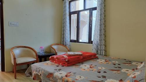 a bedroom with a bed with a red bag on it at Bhagsunag Nizu Palace in McLeod Ganj