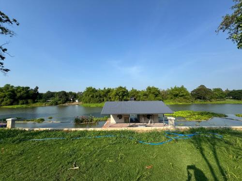 a small building on the side of a lake at สะแกกรัง ฮาเฟ่น โฮมสเตย์ Sakaekrang Haven Homestay in Uthai Thani