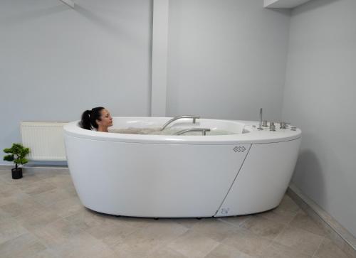 a woman sitting in a bath tub in a bathroom at Hotel Velista in Voneshta Voda