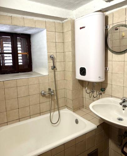 a bathroom with a bath tub and a sink at Stone house Becici in Budva