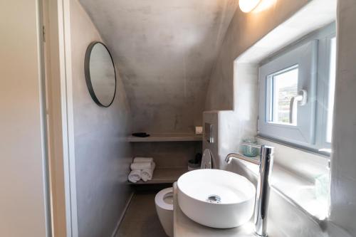 a bathroom with a white sink and a mirror at Dauti Gold Suites in Vóthon