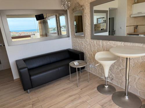 un salon avec un canapé en cuir noir et une table dans l'établissement 2 pièces, Port Nature 4 coursives, vue mer, face au Waïki, au Cap d'Agde