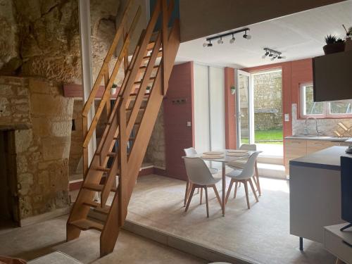 - un escalier en bois dans une cuisine avec une table et des chaises dans l'établissement La Cachette Futuroscope, à Beaumont