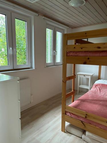 a bedroom with a bunk bed and two windows at Sjöstuga, lake view cottage in Spersboda