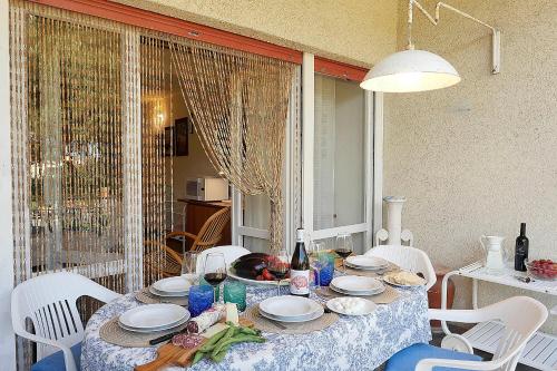 a table with white chairs and a blue and white table cloth at La Casetta Vicino al Mare in San Vincenzo