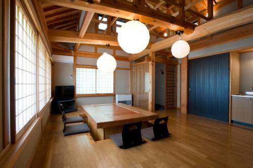a large room with a wooden table and some lights at Izumigo Takayama Dog Paradise Hotel in Takayama