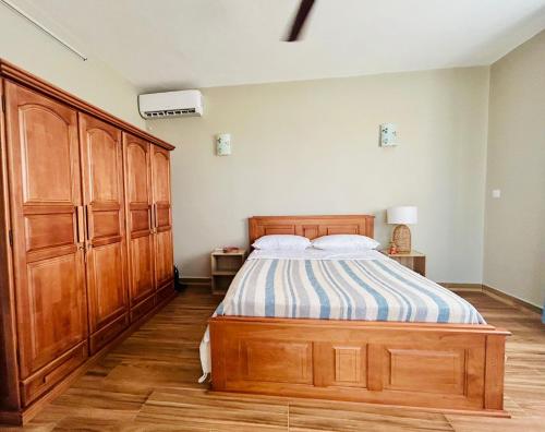 a bedroom with a bed and wooden cabinets at Lakeview Bellemare Villa in Belle Mare