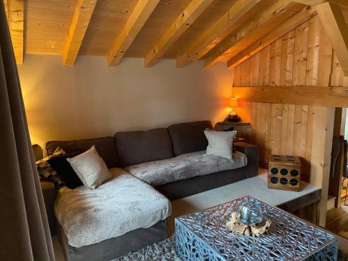ein Wohnzimmer mit Couch und Tisch in der Unterkunft Chalet Standing Jacuzzi in Samoëns