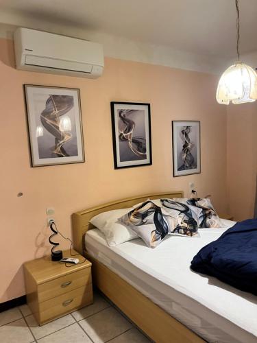 une chambre avec un lit et des tableaux au mur dans l'établissement Appartement rez-de-jardin proche du centre ville et de la cure, à Amélie-les-Bains-Palalda