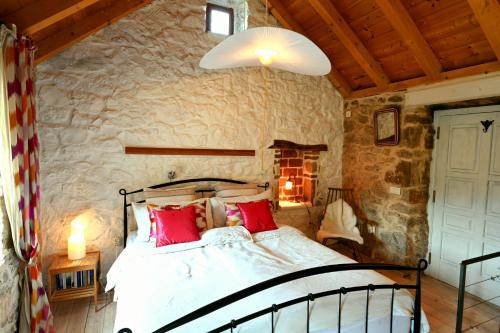 a bedroom with a bed and a stone wall at Agave in Veliko Grablje